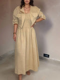 Woman wearing a beige dress and jacket in an indoor setting